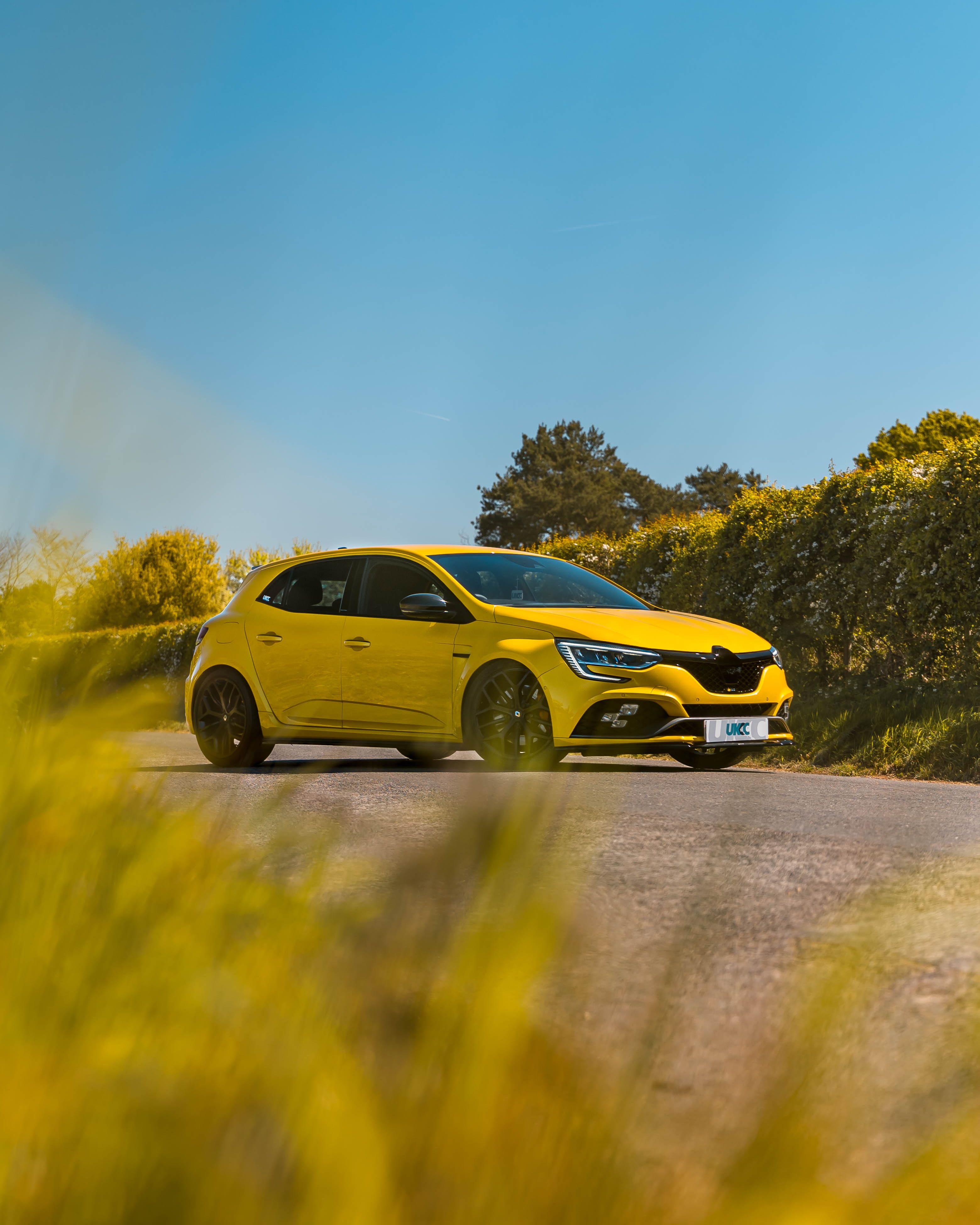 Yellow Renault Megane RS parked up 45 degree angle on road